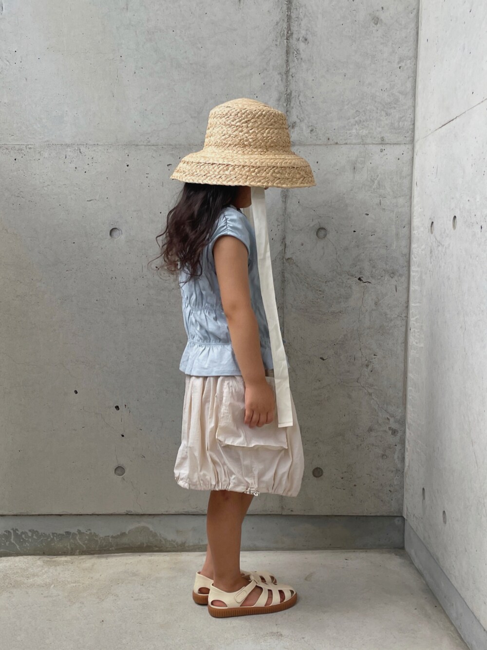 ホワイト系のサンダル、ホワイト系のスカート、ブルー系のトップスを着用したキッズの夏コーディネートの3枚目の写真