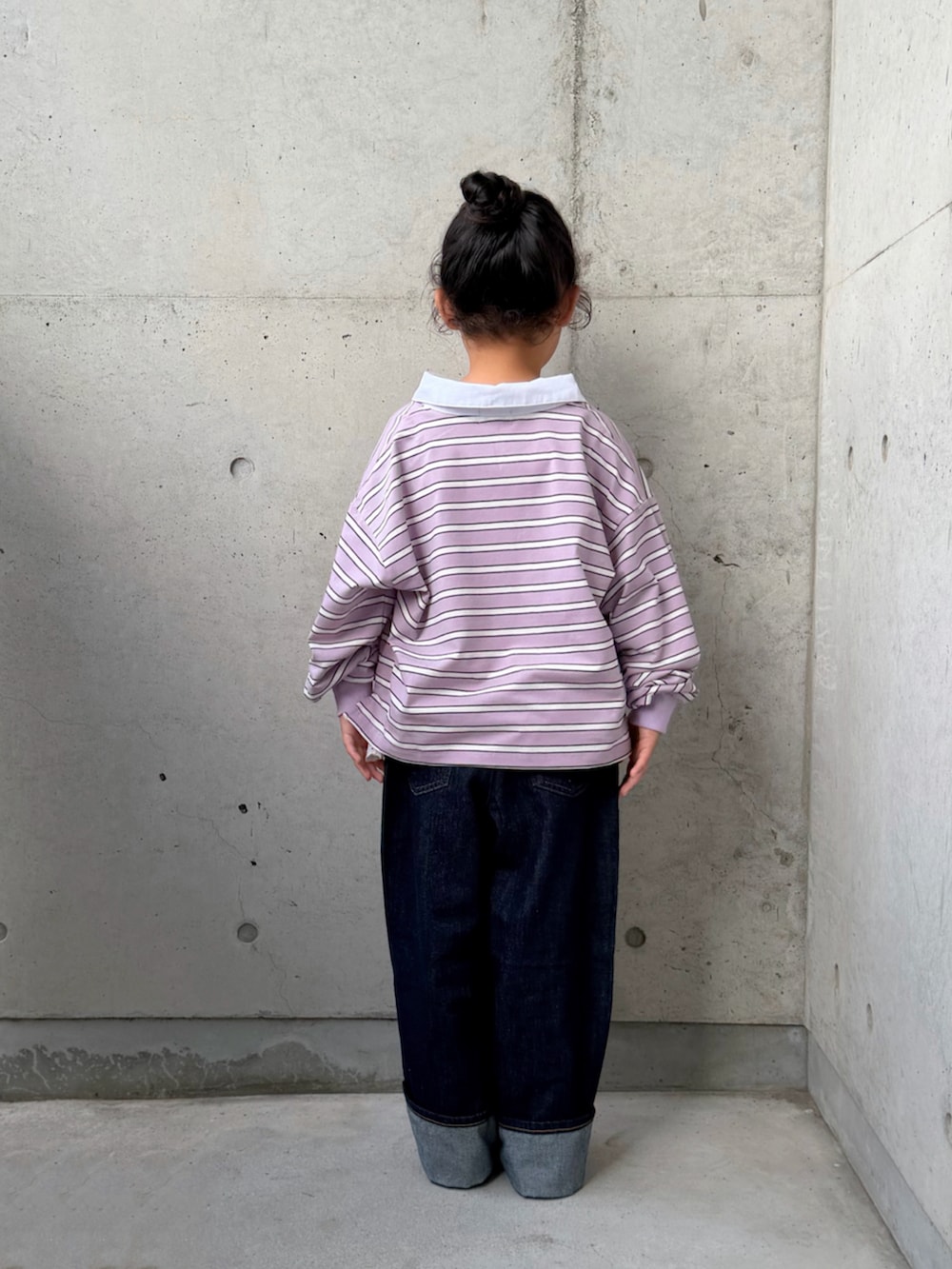 パープル系のポロシャツ、ブラック系のブーツ、ホワイト系のトップスを着用したキッズの秋コーディネートの4枚目の写真