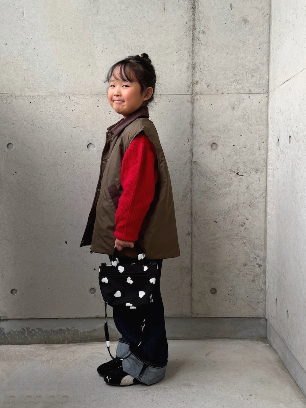 ブラック系のスニーカー、ブラック系のショルダーバッグ、グリーン系のブルゾンを着用したキッズの秋コーディネートの2枚目の写真