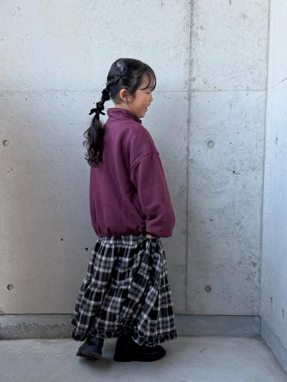 ブラウン系のブルゾン、ブラウン系のスカート、レッド系のスウェットを着用したキッズの冬コーディネートの5枚目の写真