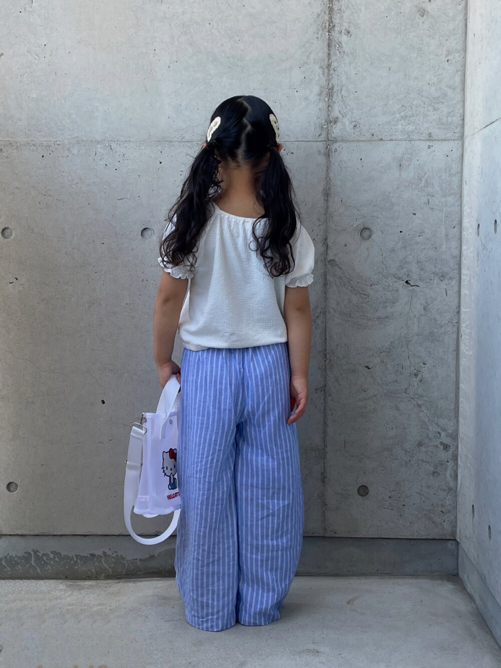 ベージュ系のサンダル、ブラック系のキャミソール、ホワイト系のトップスを着用したキッズの夏コーディネートの3枚目の写真