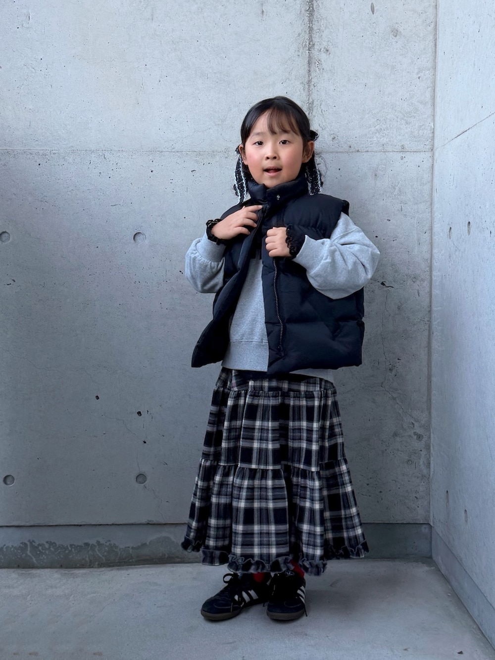 グレー系のスウェット、ブラック系のスニーカー、ブラウン系のスカートを着用したキッズの秋コーディネートの5枚目の写真