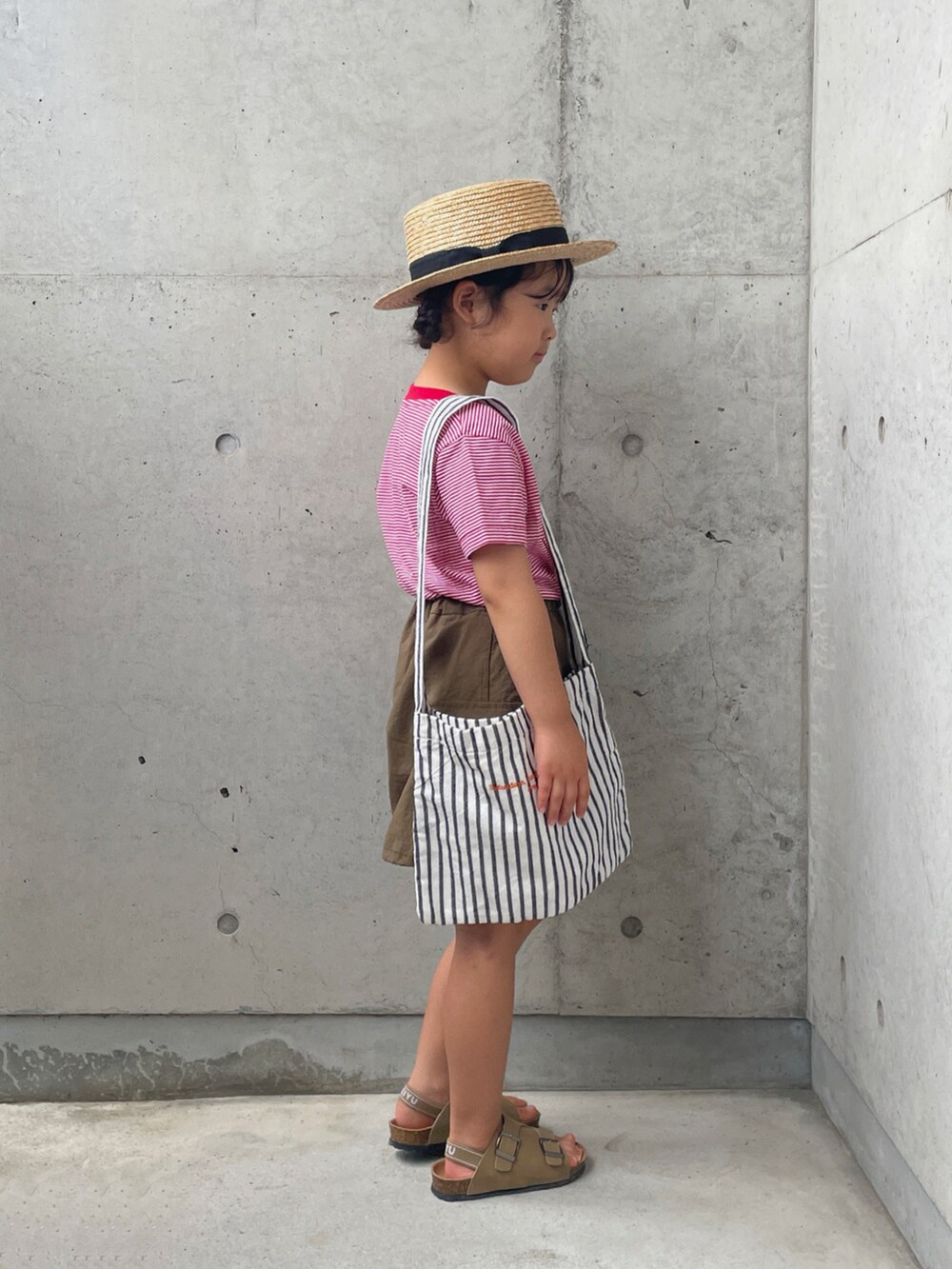 レッド系のTシャツ/カットソー、グリーン系のスカート、ホワイト系のバッグを着用したキッズの夏コーディネートの5枚目の写真