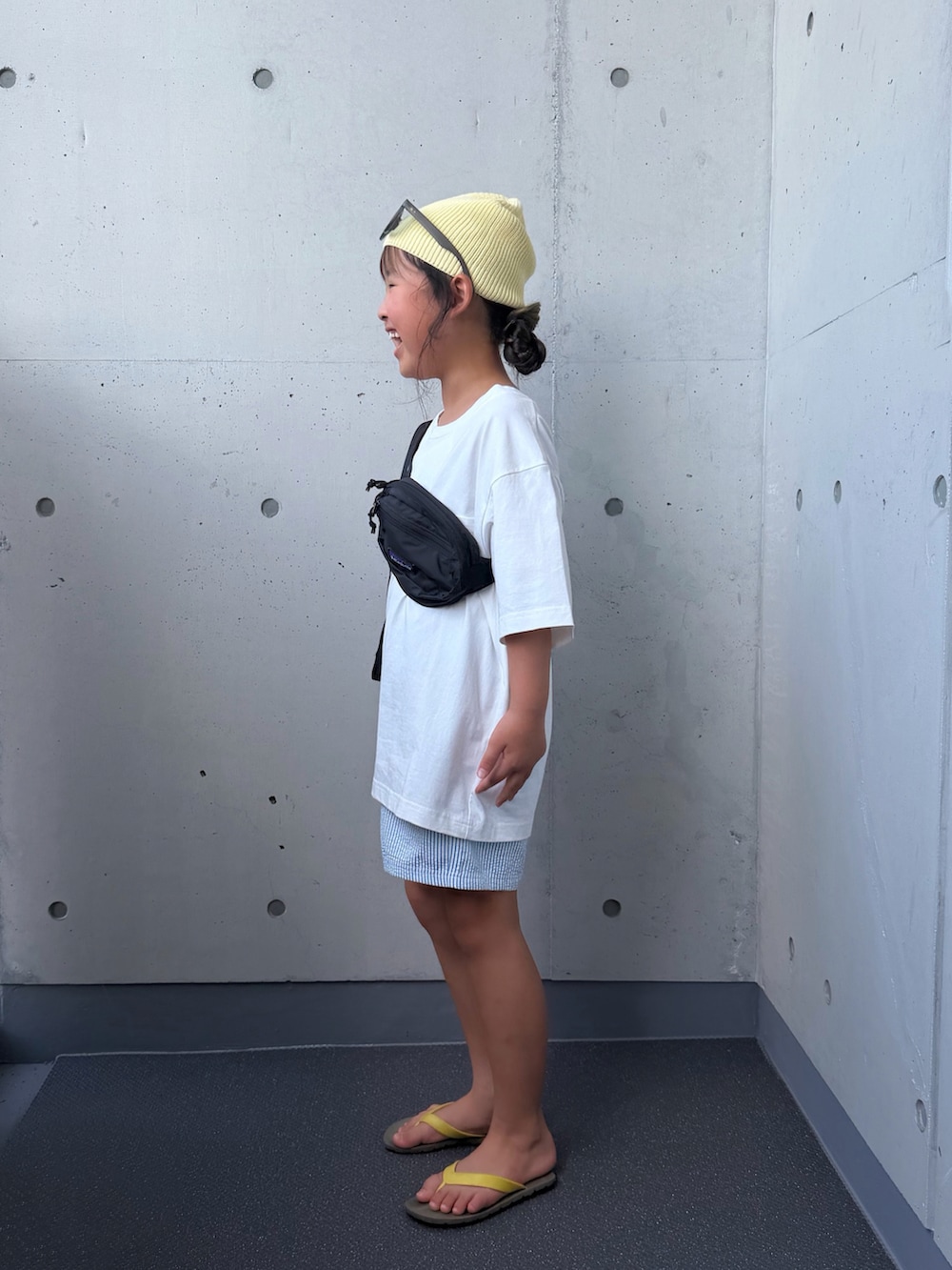 ホワイト系のTシャツ/カットソー、ブラック系のボディバッグ/ウエストポーチ、ブラウン系のサンダルを着用したキッズの夏コーディネートの2枚目の写真
