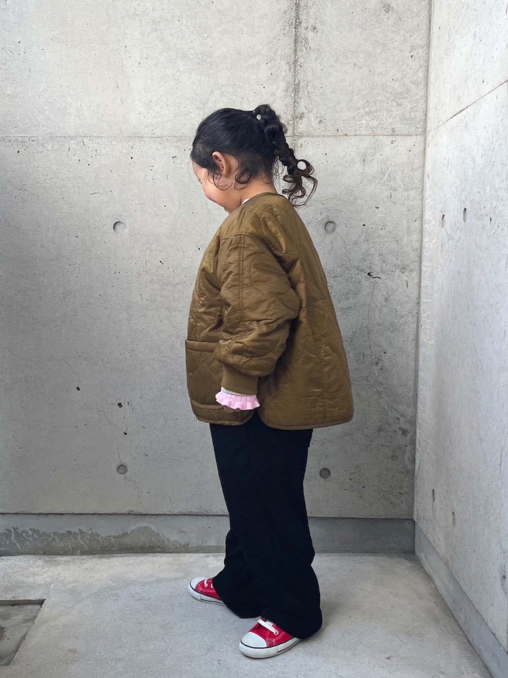 グレー系のスウェット、ブラック系のサロペット/オーバーオール、ピンク系のニット/セーターを着用したキッズの冬コーディネートの2枚目の写真