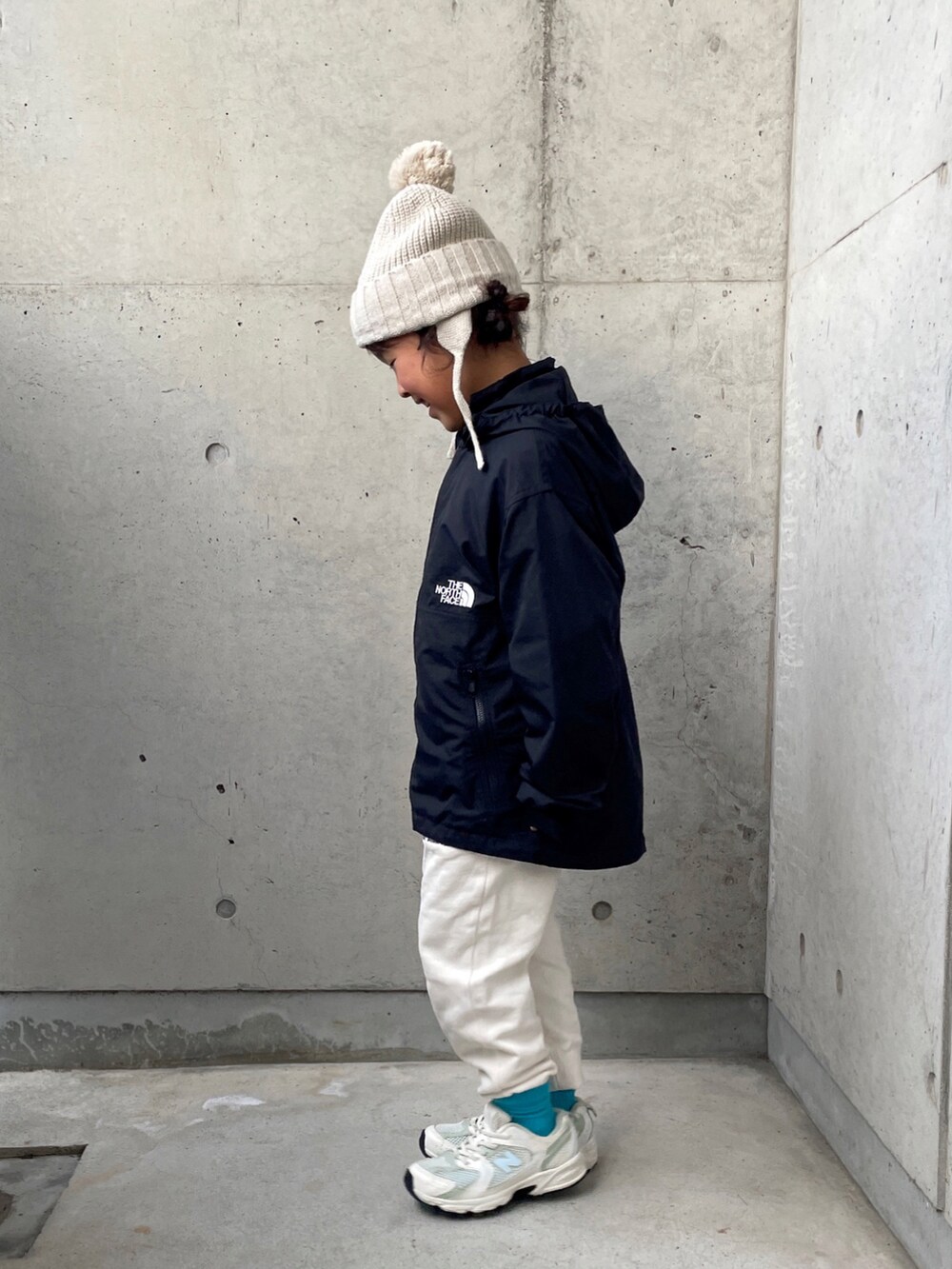 ブラック系のナイロンジャケット、ホワイト系のその他パンツ、ホワイト系のスウェットを着用したキッズの秋コーディネートの4枚目の写真