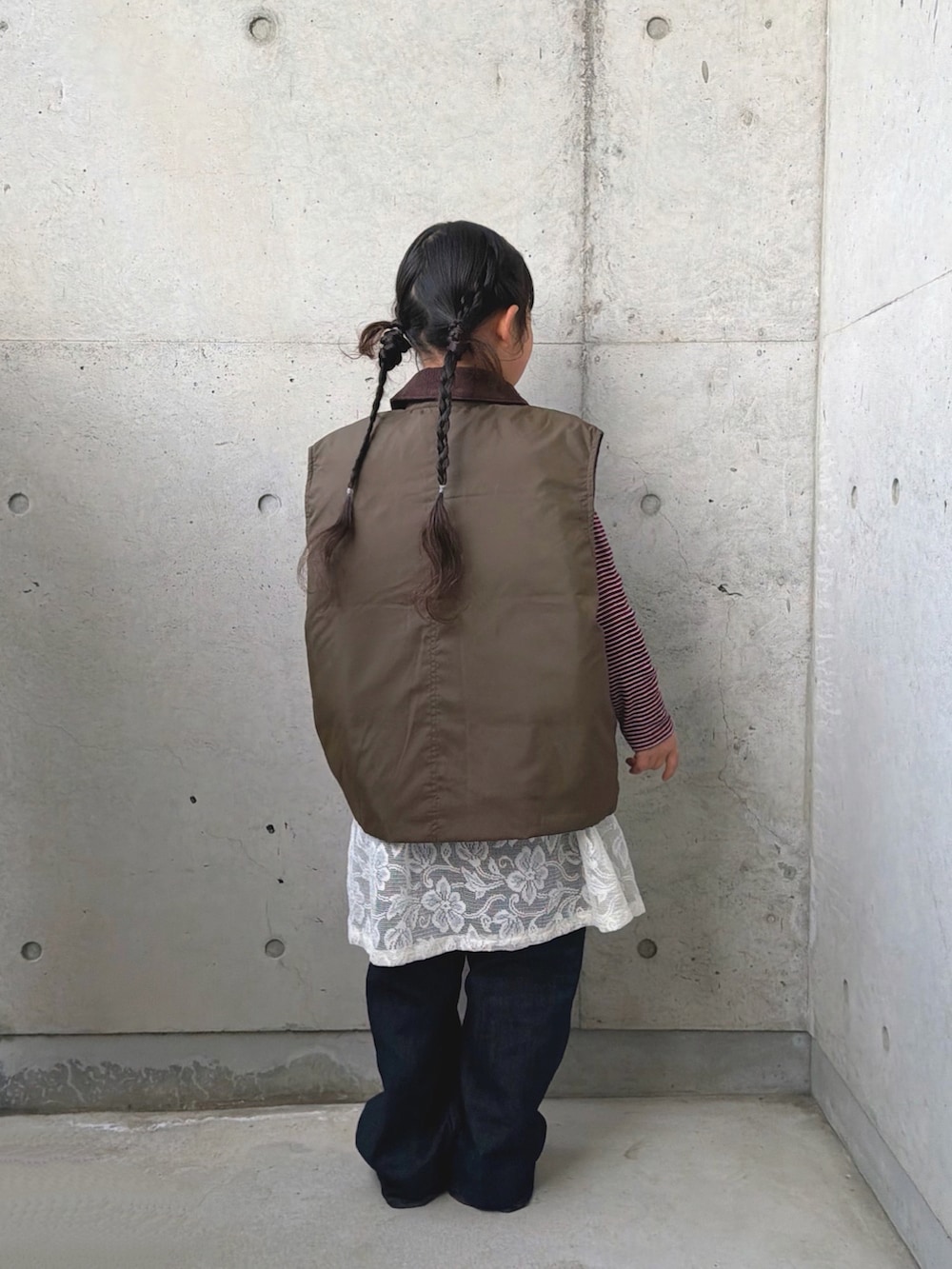 レッド系のキャミソール、レッド系のTシャツ/カットソー、グリーン系のブルゾンを着用したキッズの春コーディネートの2枚目の写真