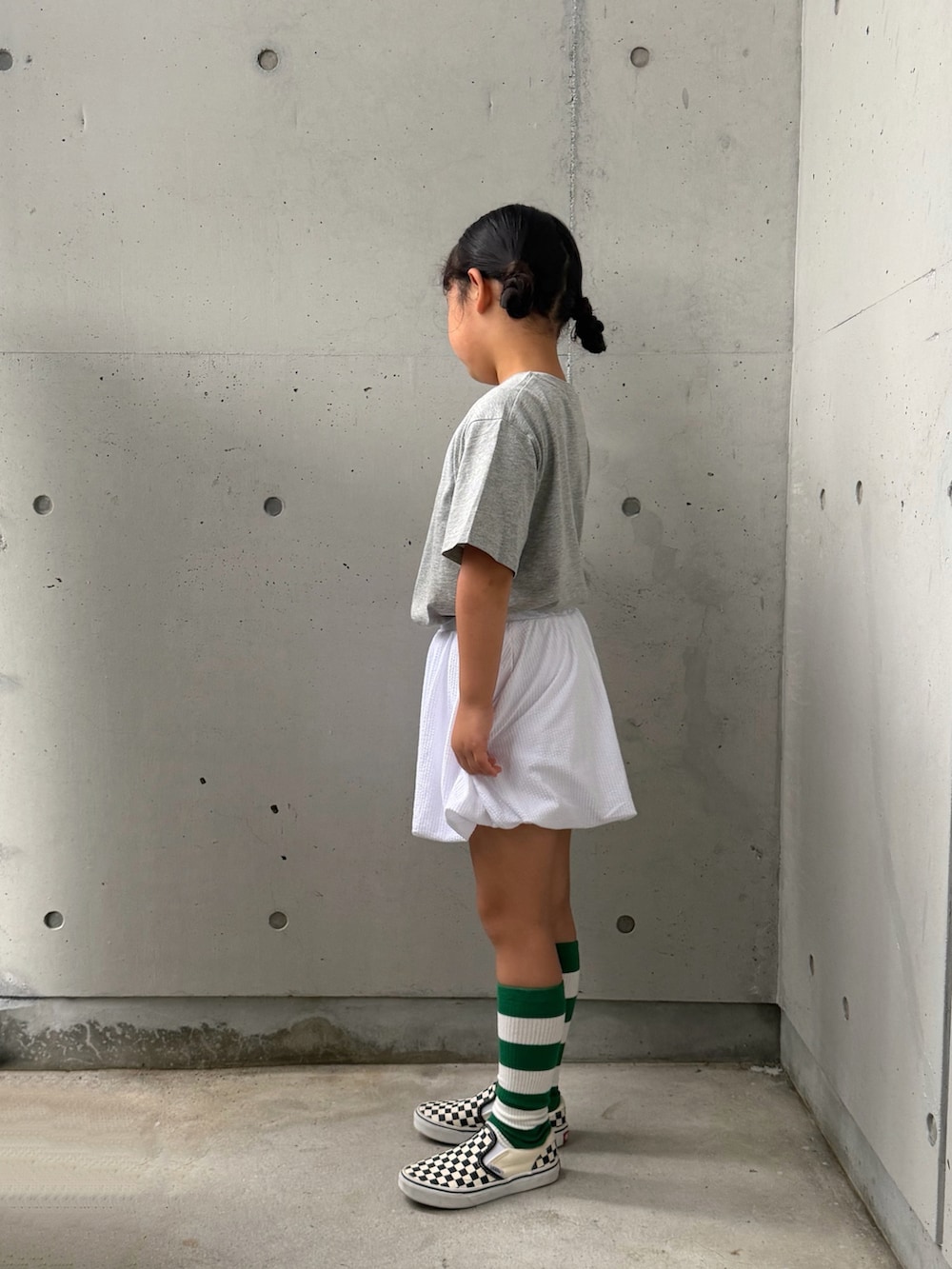 ブラック系のスリッポン、グレー系のTシャツ/カットソー、ホワイト系のスカートを着用したキッズの夏コーディネートの5枚目の写真