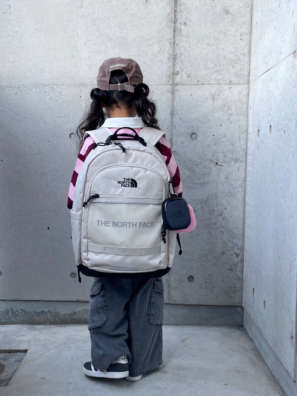 ピンク系のTシャツ/カットソー、ブラック系のパンツ、ブラック系のスニーカーを着用したキッズの冬コーディネートの3枚目の写真