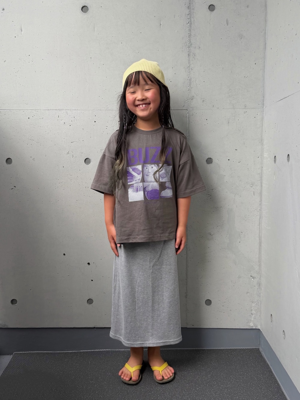 ブラック系のTシャツ/カットソー、グレー系のスカート、ブラウン系のサンダルを着用したキッズの夏コーディネートの3枚目の写真