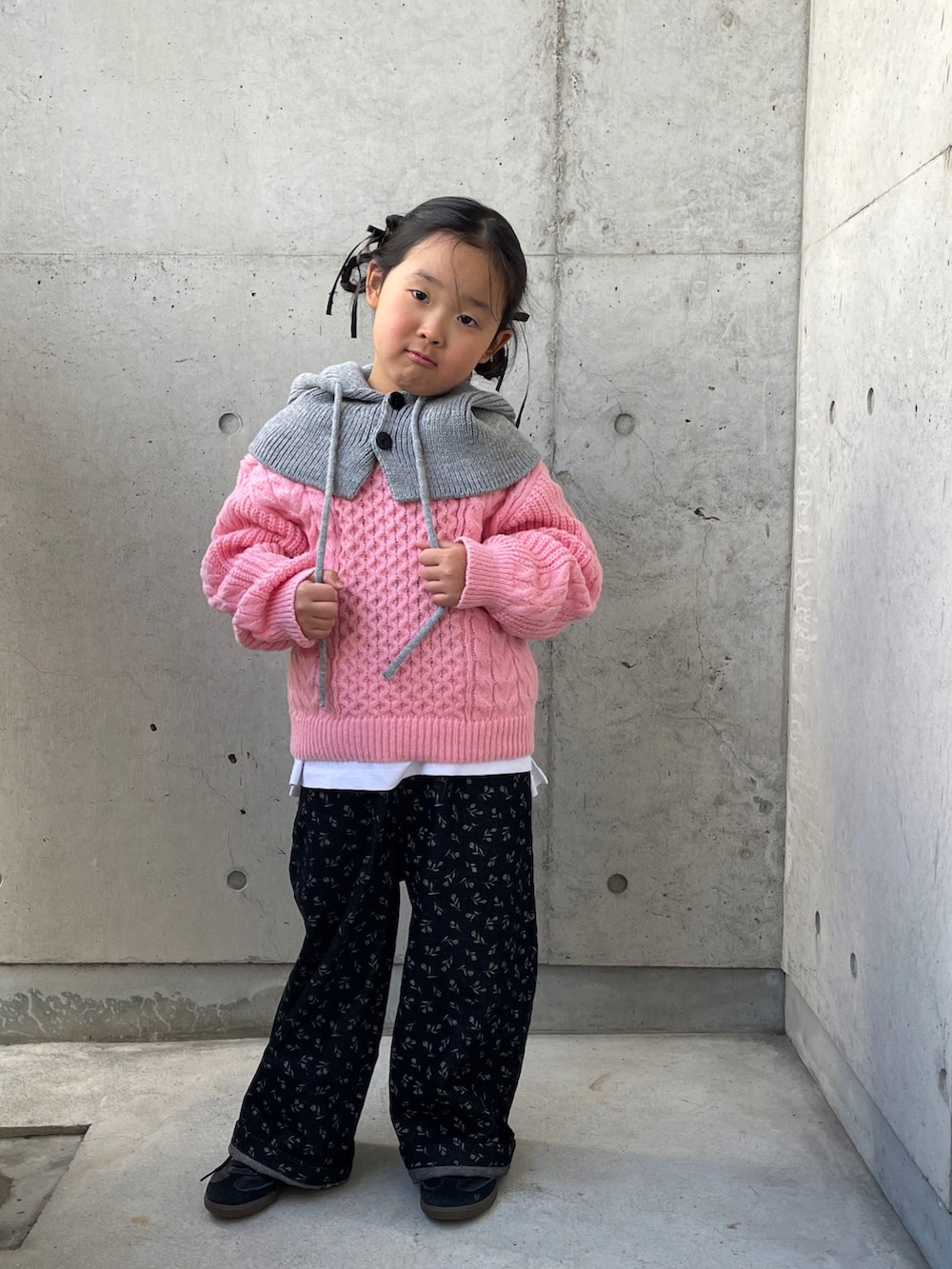 ピンク系のニット/セーター、ブラック系のオールインワン・サロペット、グリーン系のブルゾンを着用したキッズの冬コーディネートの5枚目の写真
