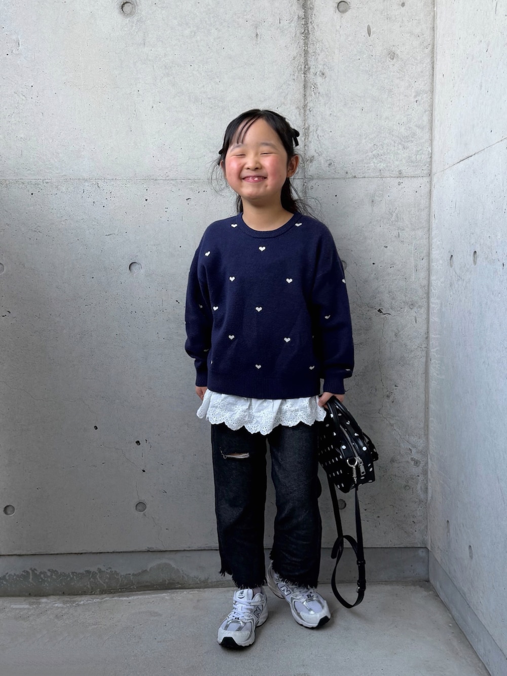 その他のボストンバッグ、ホワイト系のスニーカー、ブルー系のニット/セーターを着用したキッズの春コーディネートの3枚目の写真