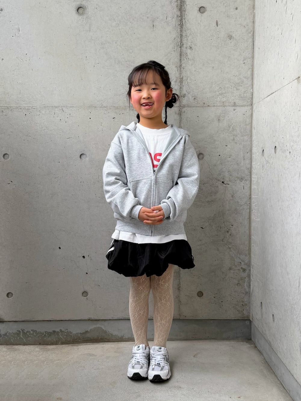 ホワイト系のTシャツ/カットソー、ブラック系のスカート、ホワイト系のスニーカーを着用したキッズの冬コーディネートの5枚目の写真