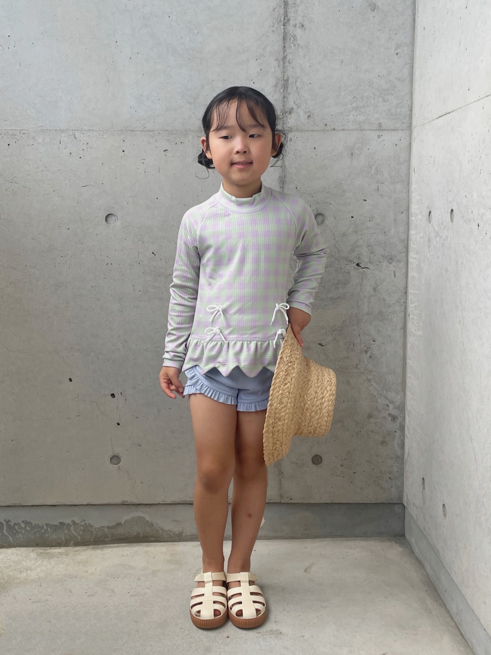 ホワイト系のサンダル、ホワイト系のバッグ、ホワイト系のハットを着用したキッズの夏コーディネートの4枚目の写真