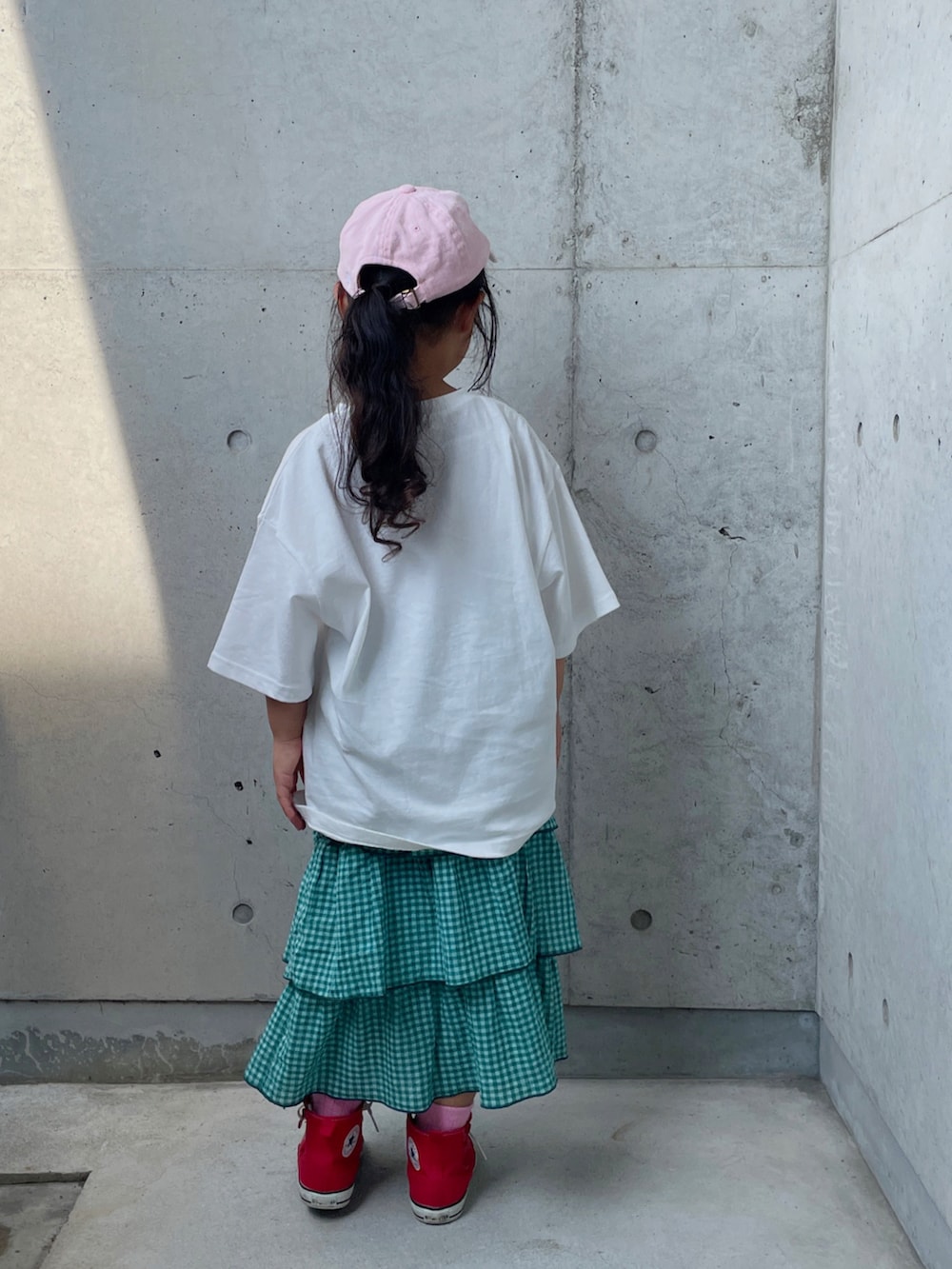 ホワイト系のTシャツ/カットソー、グリーン系のスカート、レッド系のスニーカーを着用したキッズの夏コーディネートの4枚目の写真