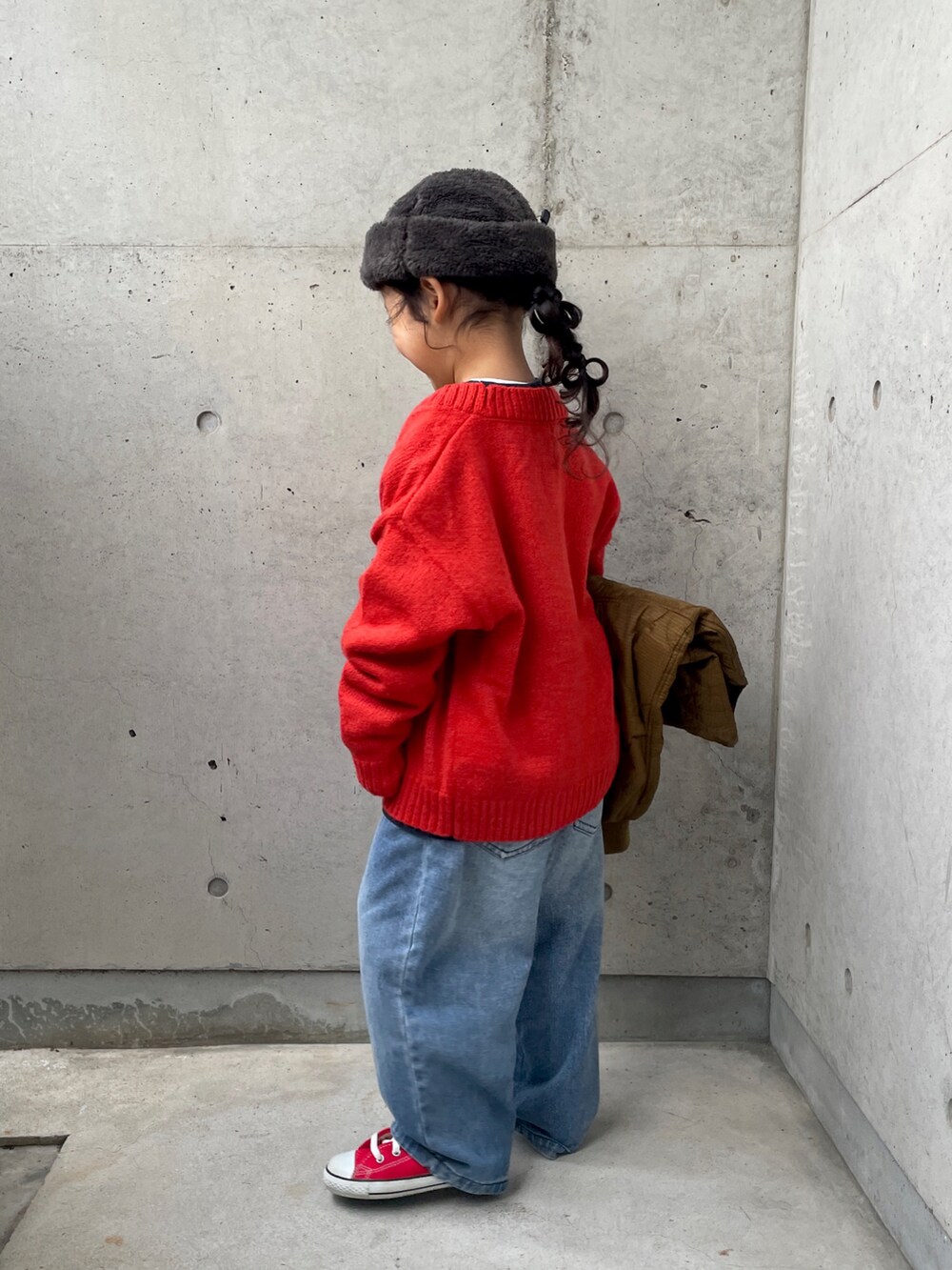 ブルー系のデニムパンツ、ブラウン系のダウンジャケット/コート、ブルー系のスウェットを着用したキッズの冬コーディネートの5枚目の写真