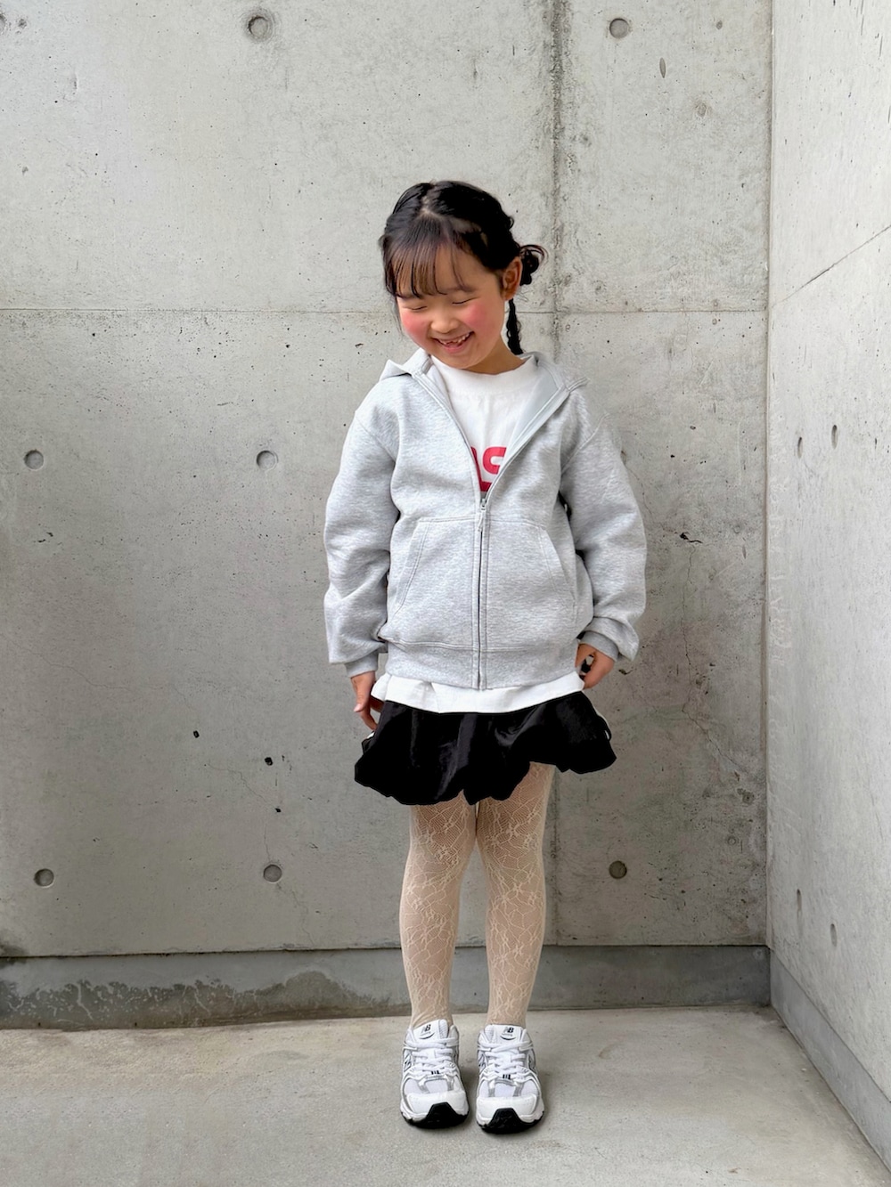 ホワイト系のTシャツ/カットソー、ブラック系のスカート、ホワイト系のスニーカーを着用したキッズの冬コーディネートの3枚目の写真