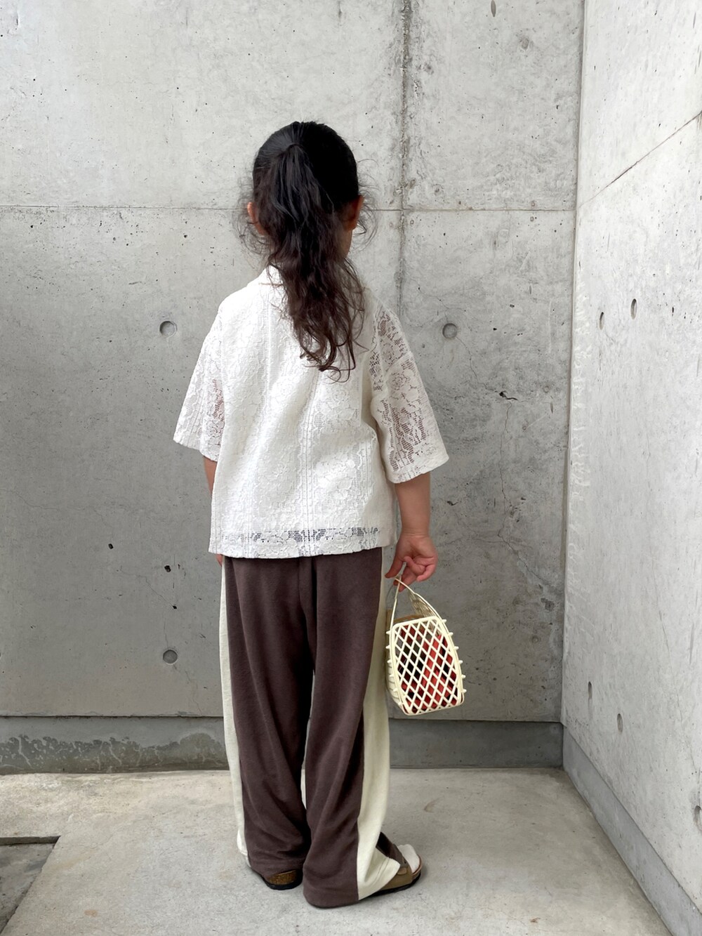 ブラウン系のその他パンツ、ホワイト系のシャツ/ブラウス、ホワイト系のバッグを着用したキッズの春コーディネートの3枚目の写真