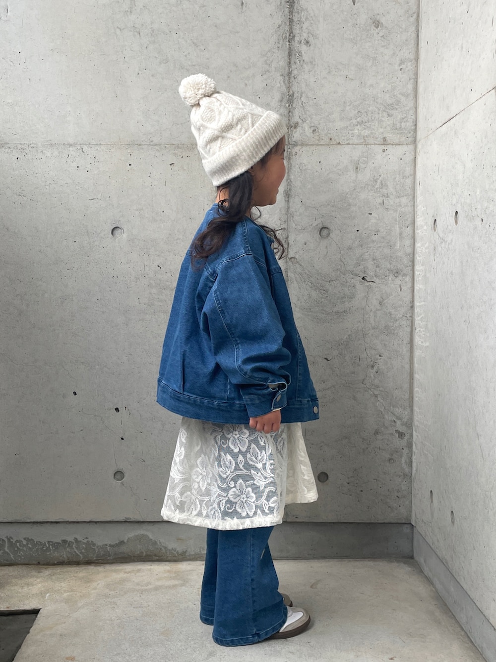 ブルー系のデニムジャケット、ホワイト系のスウェット、ホワイト系のスカートを着用したキッズの冬コーディネートの3枚目の写真