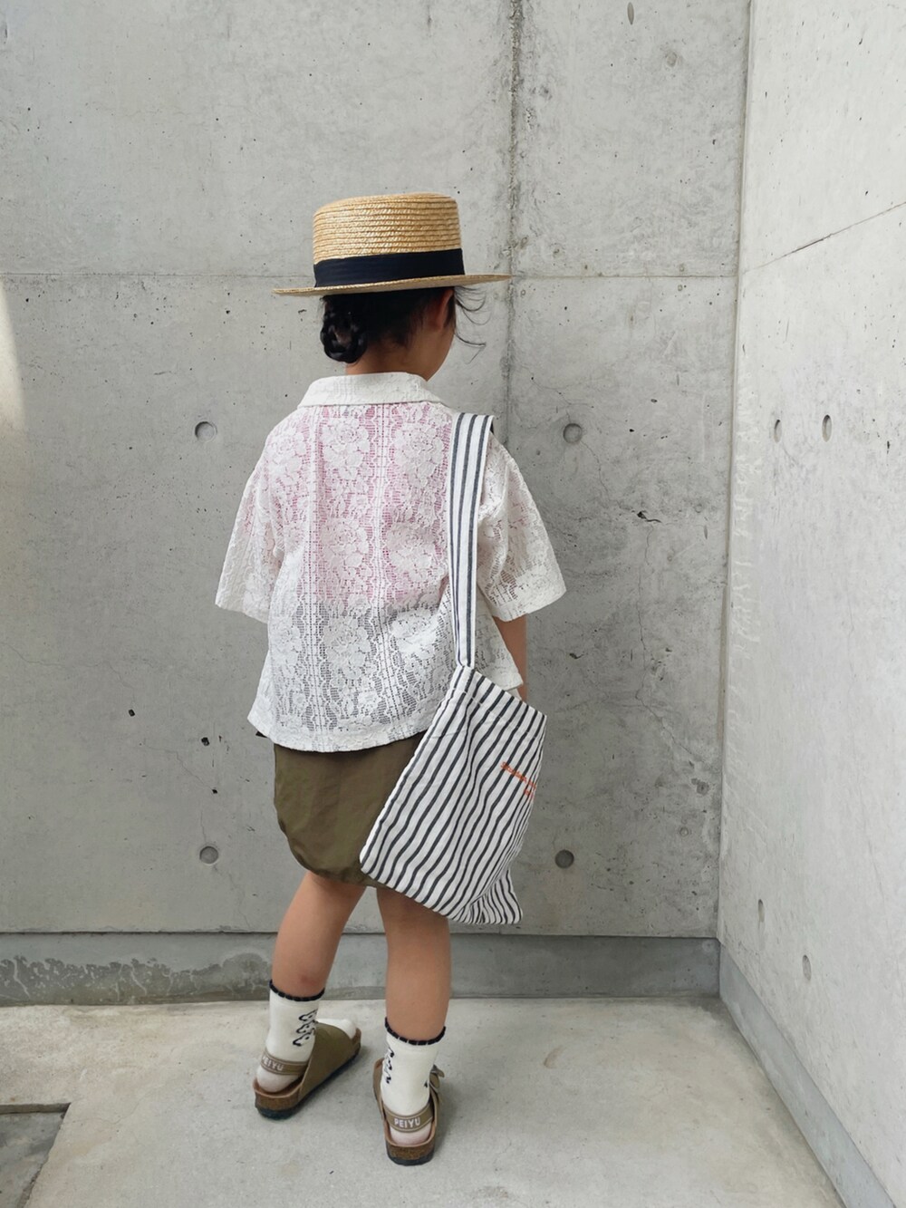 レッド系のTシャツ/カットソー、ホワイト系のシャツ/ブラウス、グリーン系のスカートを着用したキッズの春コーディネートの3枚目の写真