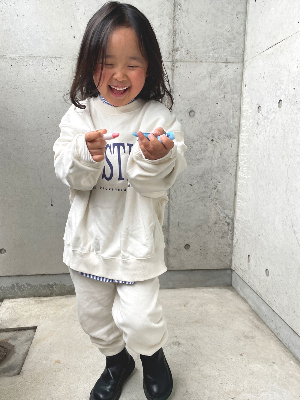 ブラック系のブーツ、ホワイト系のスウェット、ホワイト系のその他パンツを着用したキッズの春コーディネートの2枚目の写真