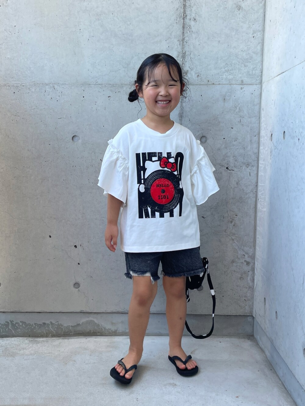 ブラック系のデニムパンツ、ブラック系のサンダル、ブラック系のショルダーバッグを着用したキッズの夏コーディネートの5枚目の写真