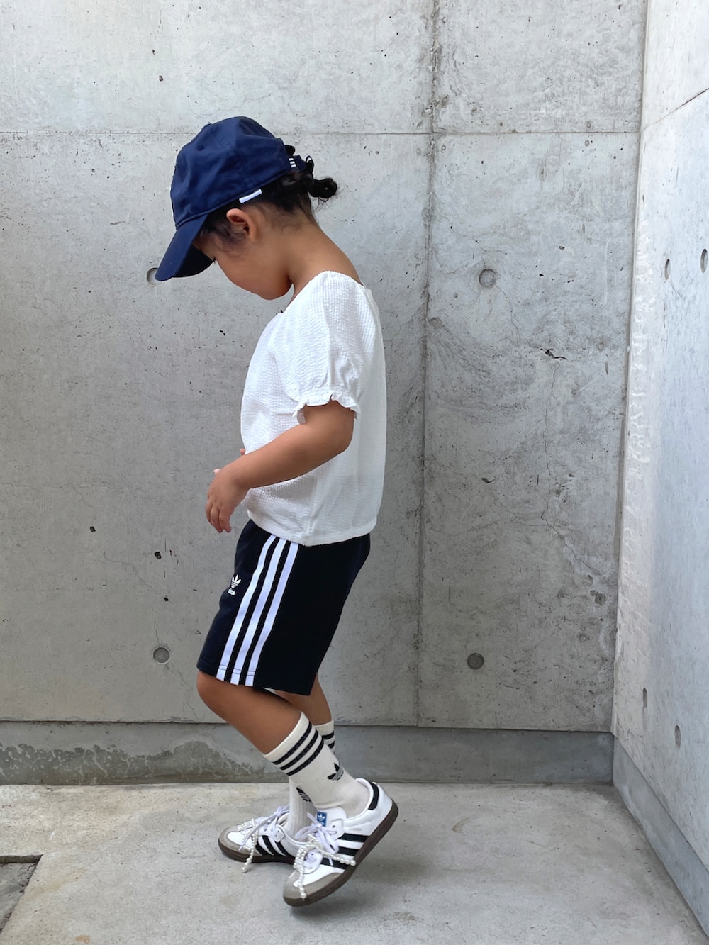 ホワイト系のトップス、ブラック系のその他パンツ、ホワイト系のスニーカーを着用したキッズの秋コーディネートの3枚目の写真