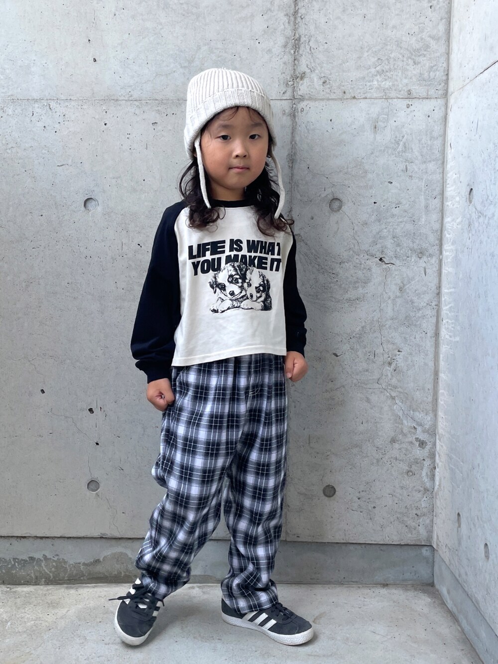 ブラック系のスニーカー、ブラック系のパンツ、ホワイト系のトップスを着用したキッズの秋コーディネートの2枚目の写真