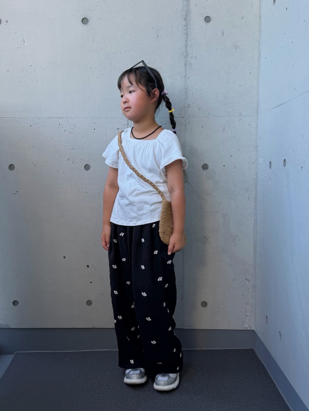 ブラック系のその他パンツ、ベージュ系のショルダーバッグ、シルバー系のスニーカーを着用したキッズの夏コーディネートの3枚目の写真