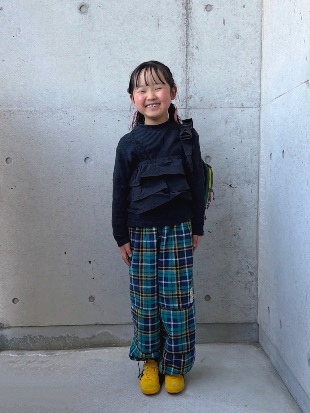 イエロー系のスニーカー、ブラック系のTシャツ/カットソー、グリーン系のパンツを着用したキッズの春コーディネートの3枚目の写真