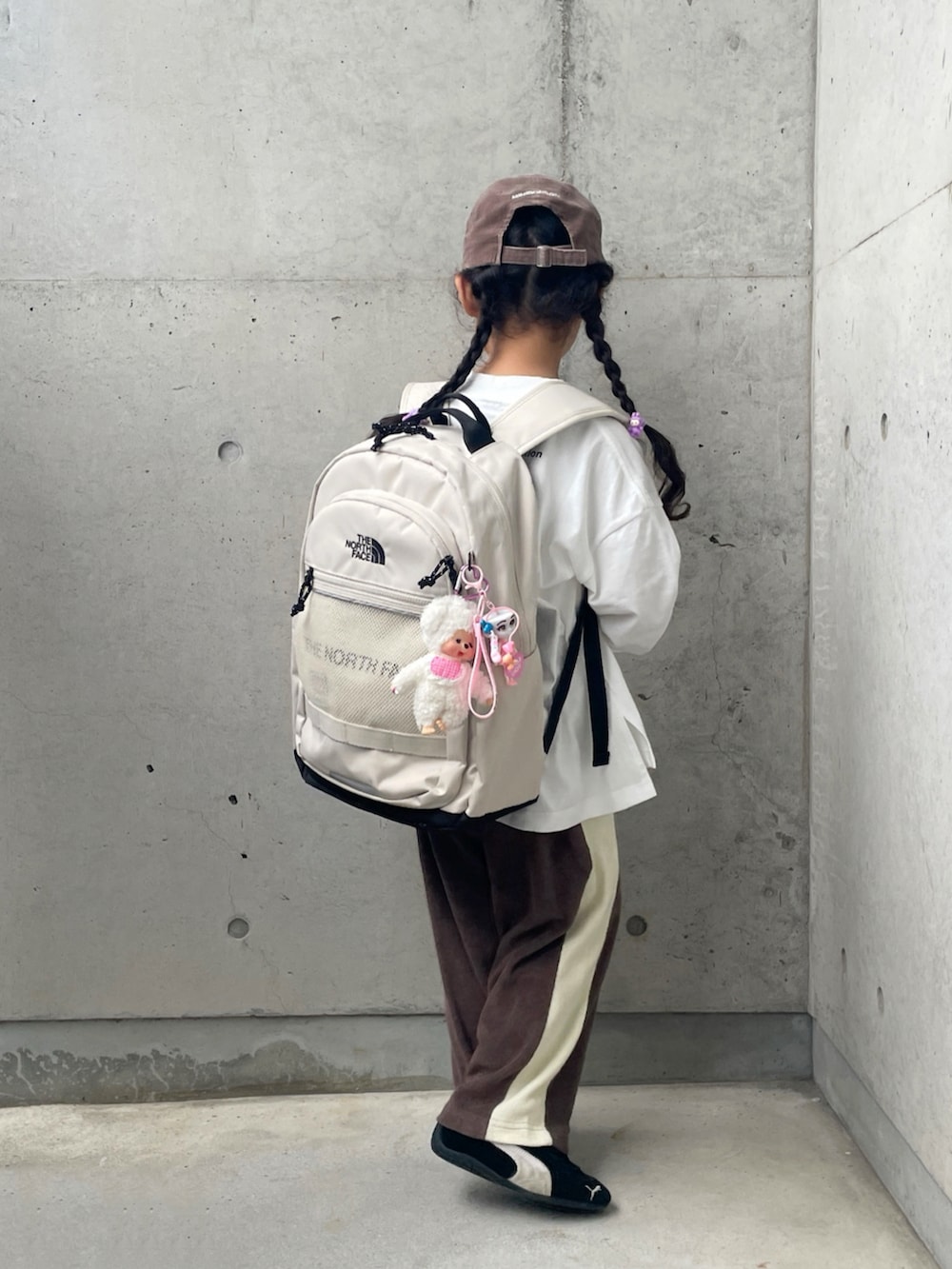 ホワイト系のTシャツ/カットソー、ブラック系のスニーカー、ブラウン系のその他パンツを着用したキッズの秋コーディネートの3枚目の写真