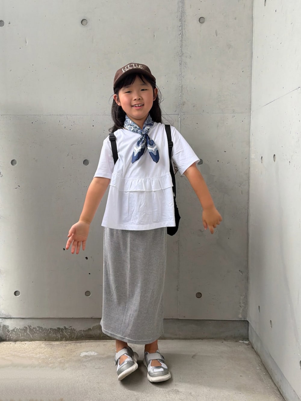 グレー系のスカート、シルバー系のスニーカー、ホワイト系のTシャツ/カットソーを着用したキッズの夏コーディネートの5枚目の写真