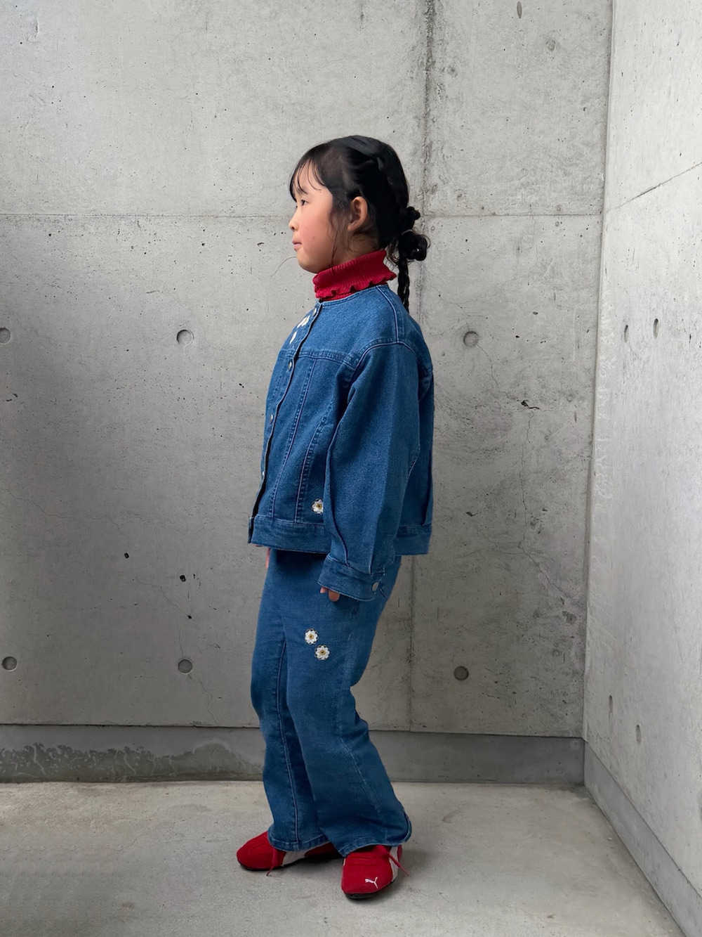 レッド系のニット/セーター、レッド系のスニーカー、ブルー系のデニムジャケットを着用したキッズの冬コーディネートの4枚目の写真