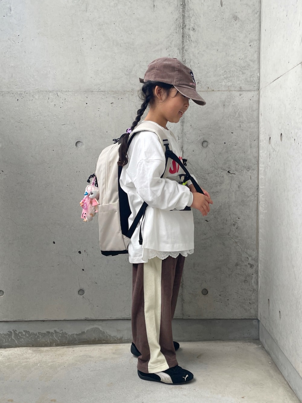 ホワイト系のTシャツ/カットソー、ブラック系のスニーカー、ブラウン系のその他パンツを着用したキッズの秋コーディネートの2枚目の写真