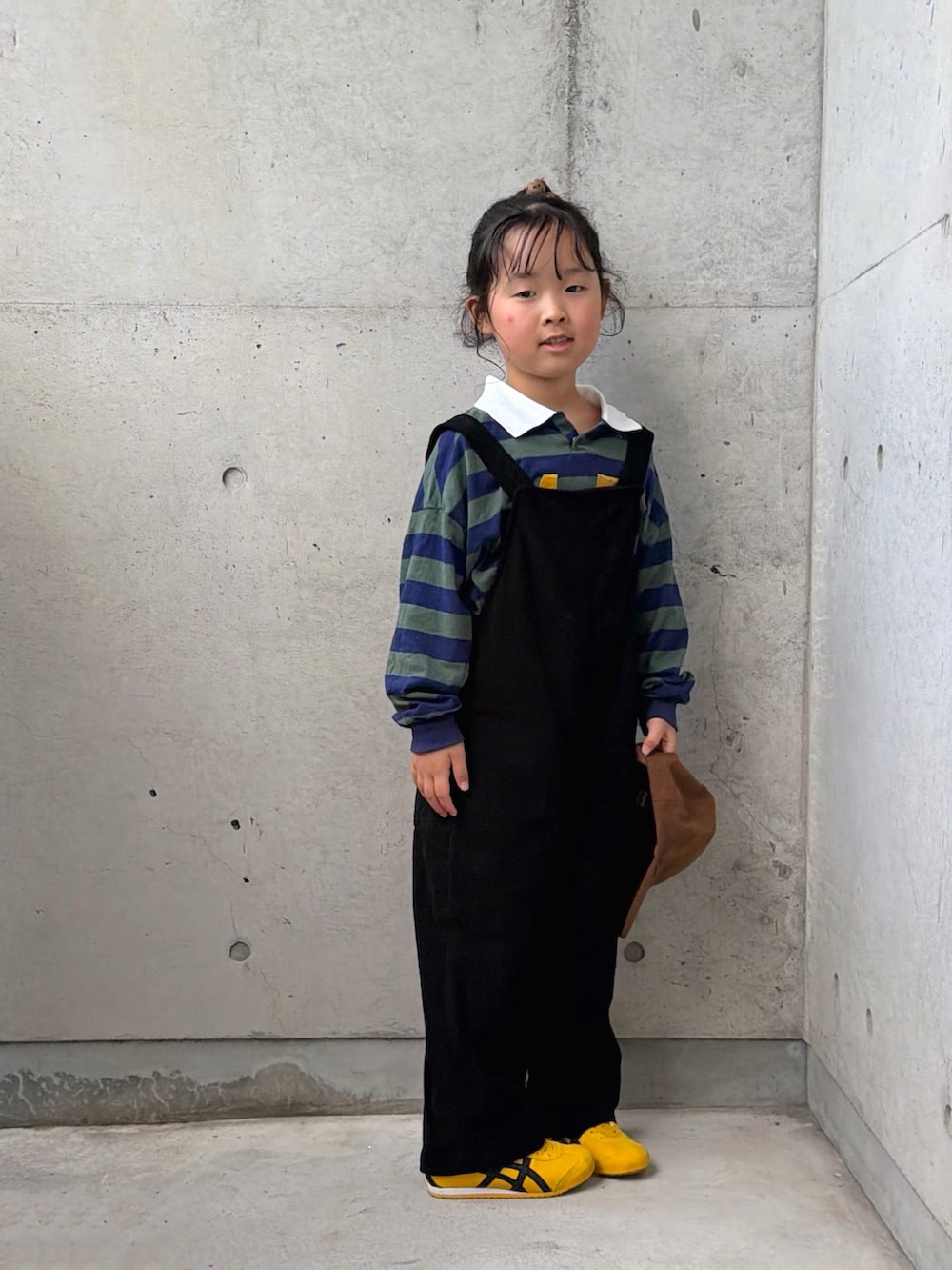 グリーン系のポロシャツ、イエロー系のスニーカー、ブラック系のサロペット/オーバーオールを着用したキッズの秋コーディネートの4枚目の写真