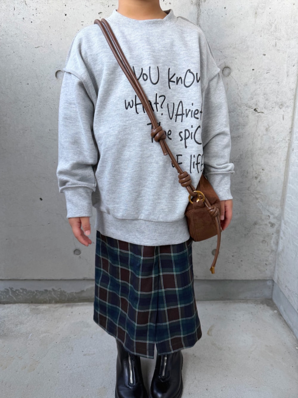 グレー系のTシャツ/カットソー、ブラウン系のスカート、ブラック系のブーツを着用したキッズの秋コーディネートの3枚目の写真