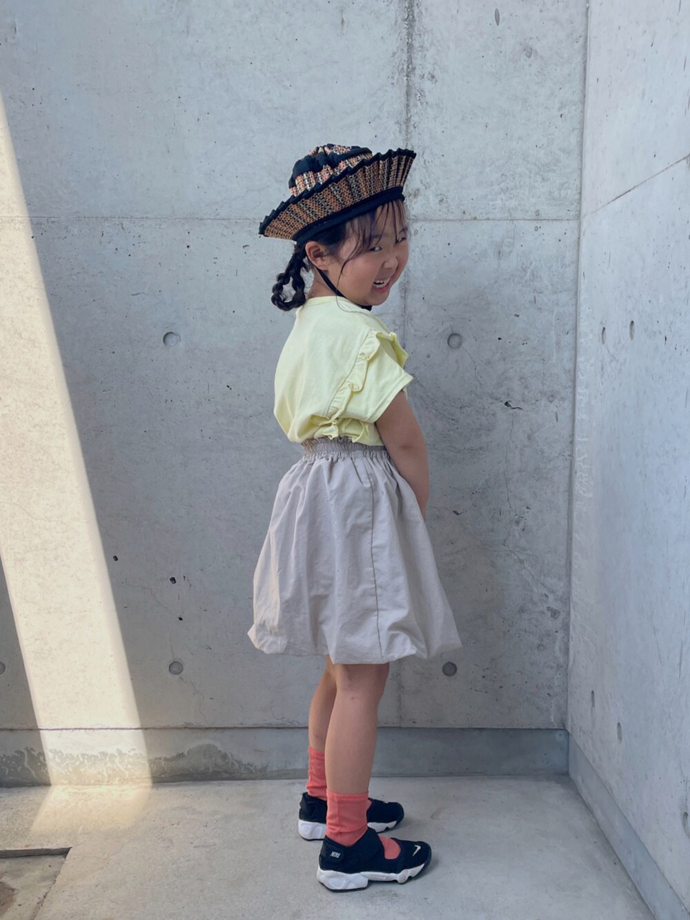 ブラック系のスニーカー、ベージュ系のTシャツ/カットソー、ベージュ系のスカートを着用したキッズの夏コーディネートの5枚目の写真