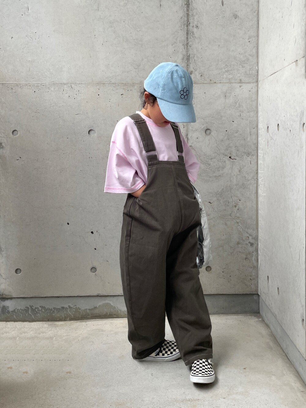 グレー系のサロペット/オーバーオール、ブラック系のスリッポン、パープル系のTシャツ/カットソーを着用したキッズの秋コーディネートの4枚目の写真