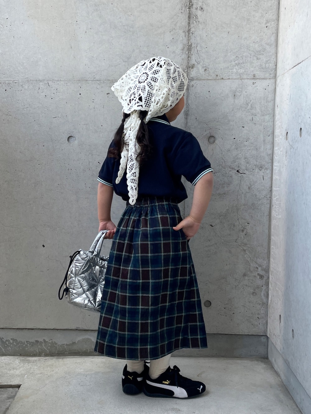 ブラウン系のスカート、ブルー系のポロシャツ、ブラック系のスニーカーを着用したキッズの春コーディネートの3枚目の写真