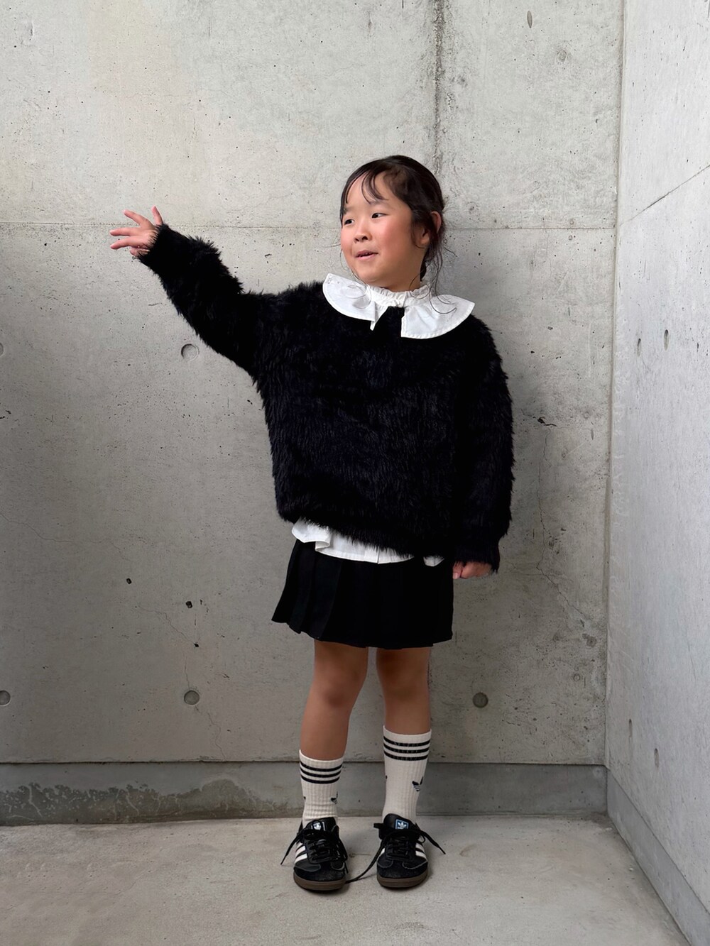 ブラック系のニット/セーター、ブラック系のスニーカー、ホワイト系のシャツ/ブラウスを着用したキッズの秋コーディネートの5枚目の写真
