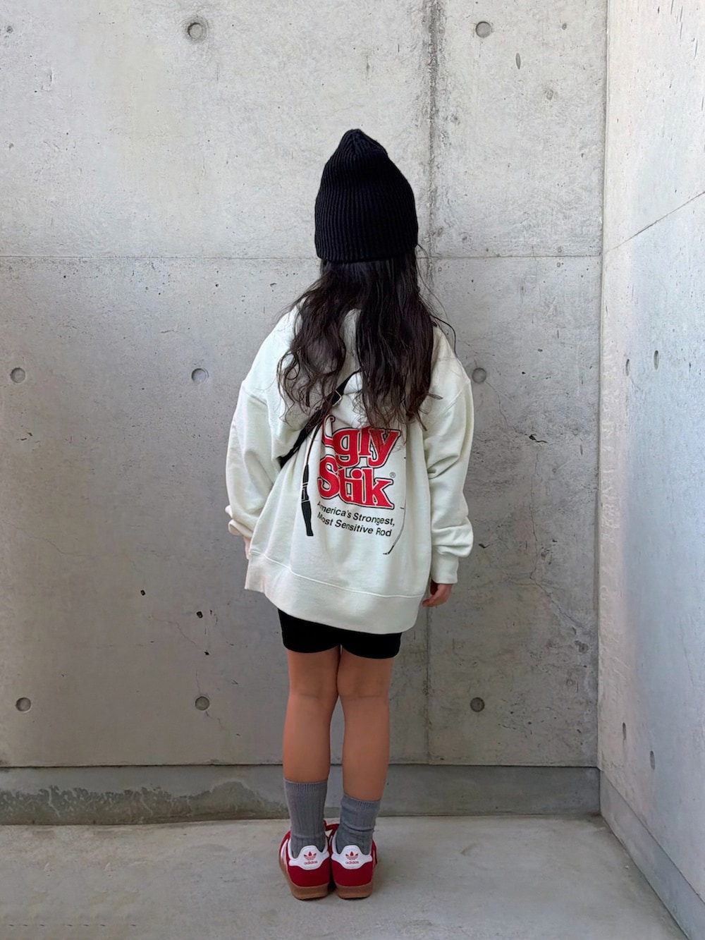 ホワイト系のパーカー、ブラック系のショルダーバッグ、レッド系のスニーカーを着用したキッズの冬コーディネートの4枚目の写真