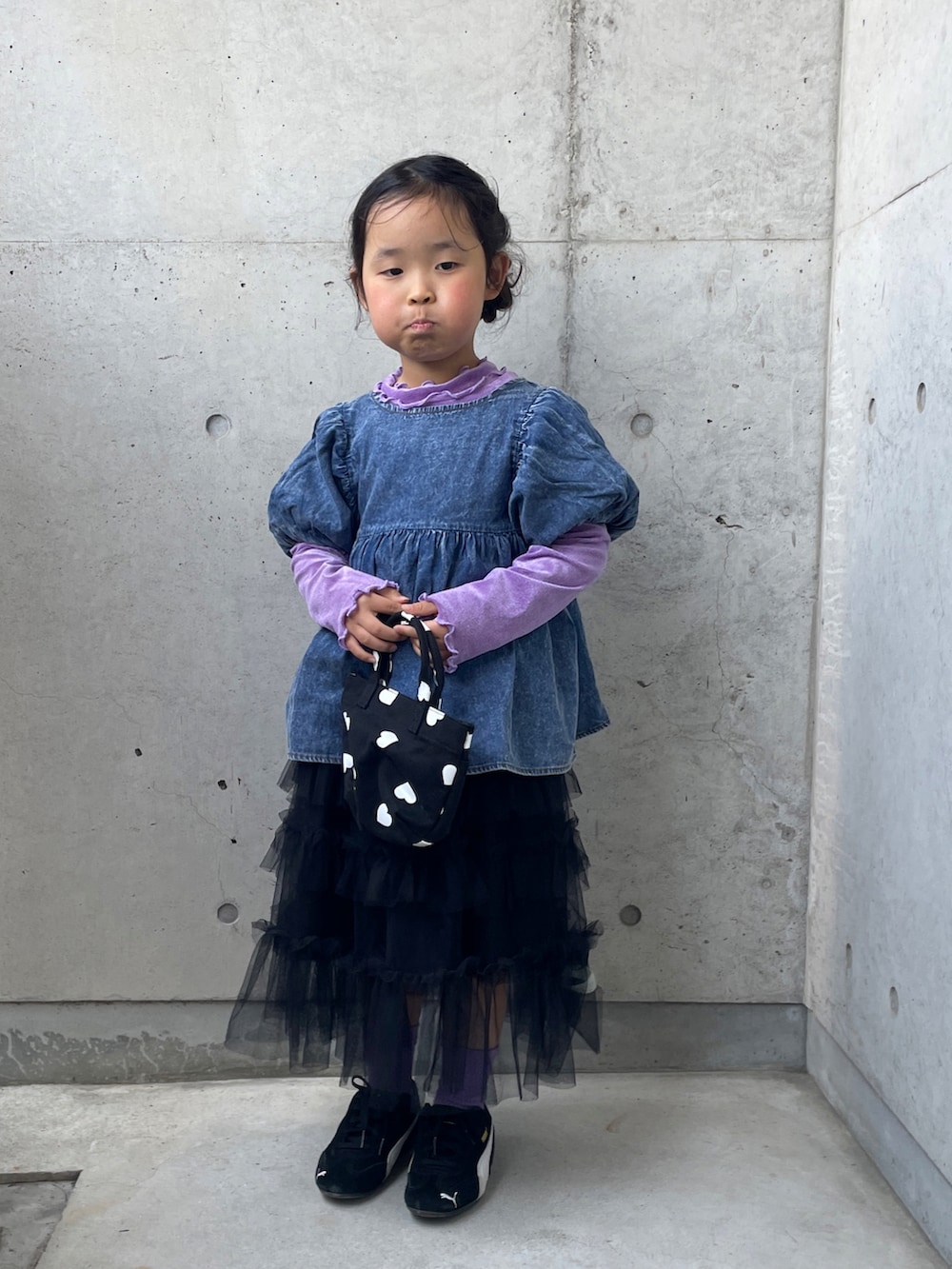 ブラック系のスニーカー、ブラック系のスカート、パープル系のTシャツ/カットソーを着用したキッズの春コーディネートの3枚目の写真