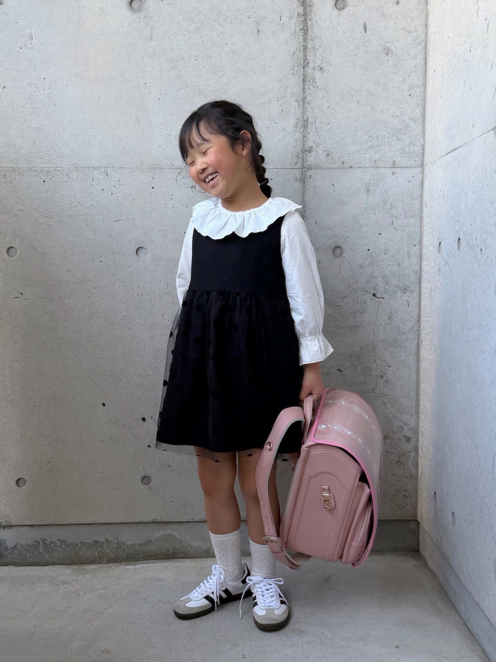 ホワイト系のシャツ/ブラウス、ブラック系のワンピース、ピンク系のトートバッグを着用したキッズの春コーディネートの5枚目の写真