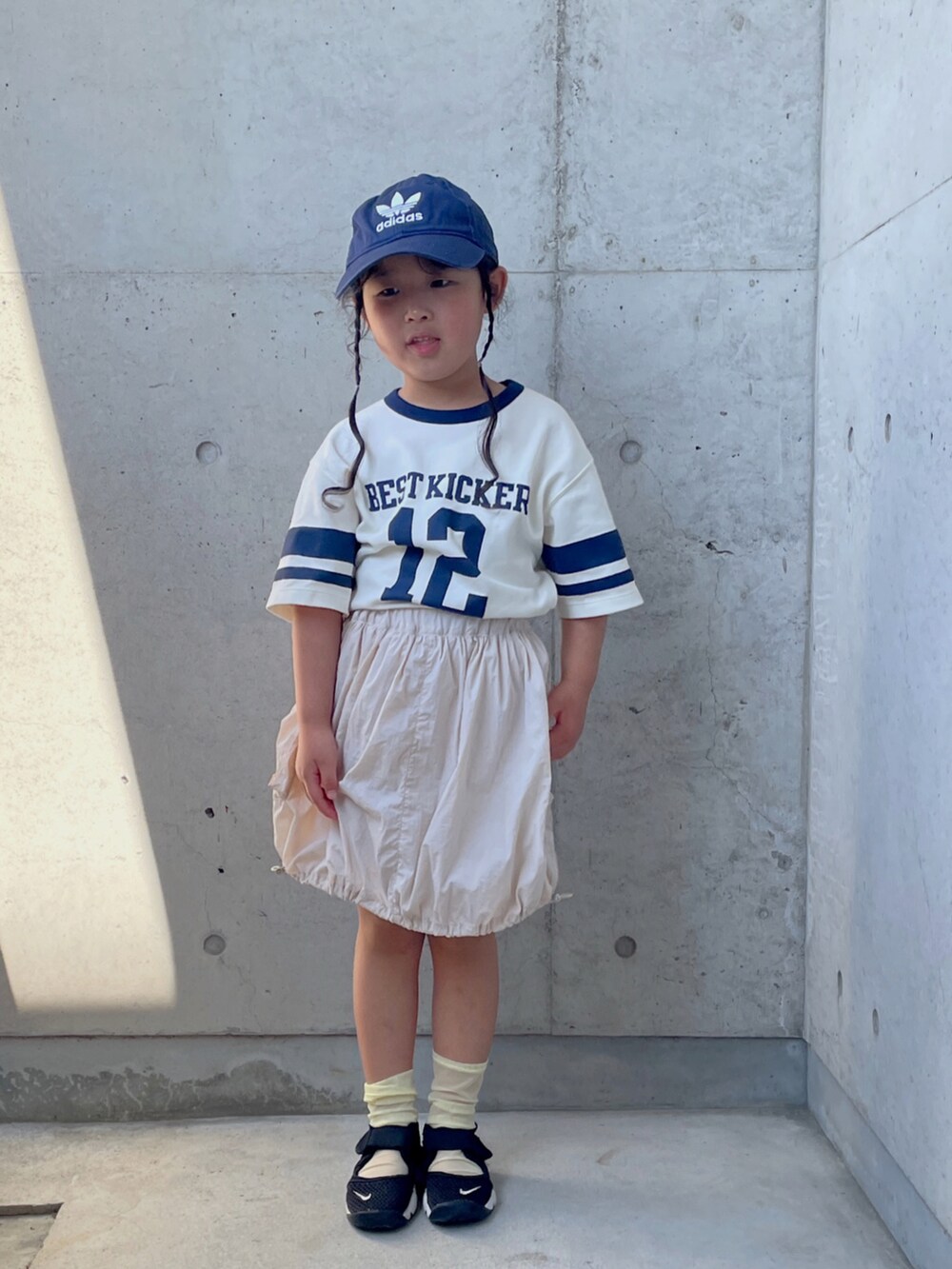 グリーン系のTシャツ/カットソー、ホワイト系のスカート、ブラック系のスニーカーを着用したキッズの夏コーディネートの5枚目の写真