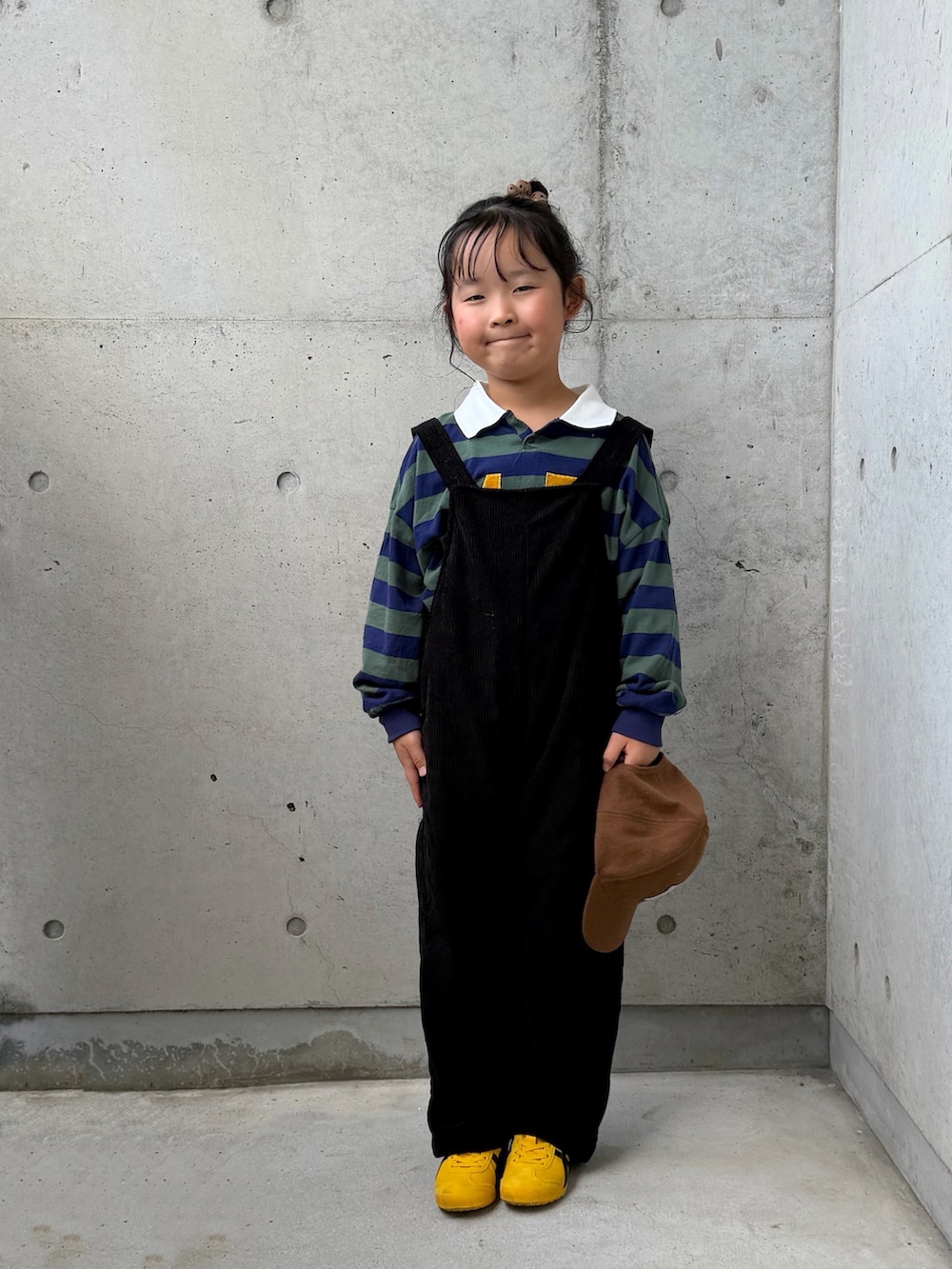 グリーン系のポロシャツ、イエロー系のスニーカー、ブラック系のサロペット/オーバーオールを着用したキッズの秋コーディネートの2枚目の写真