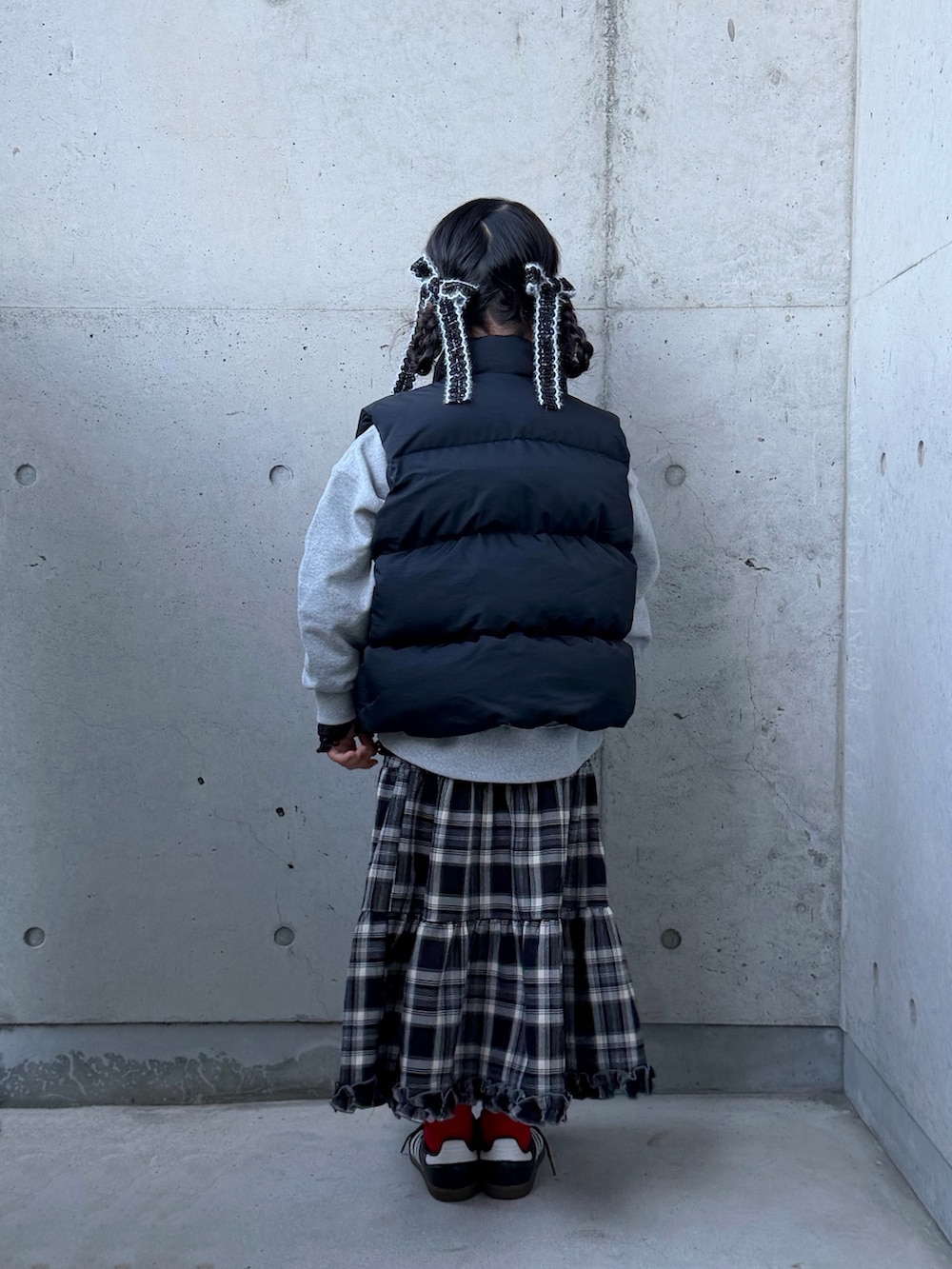 グレー系のスウェット、ブラック系のスニーカー、ブラウン系のスカートを着用したキッズの秋コーディネートの4枚目の写真