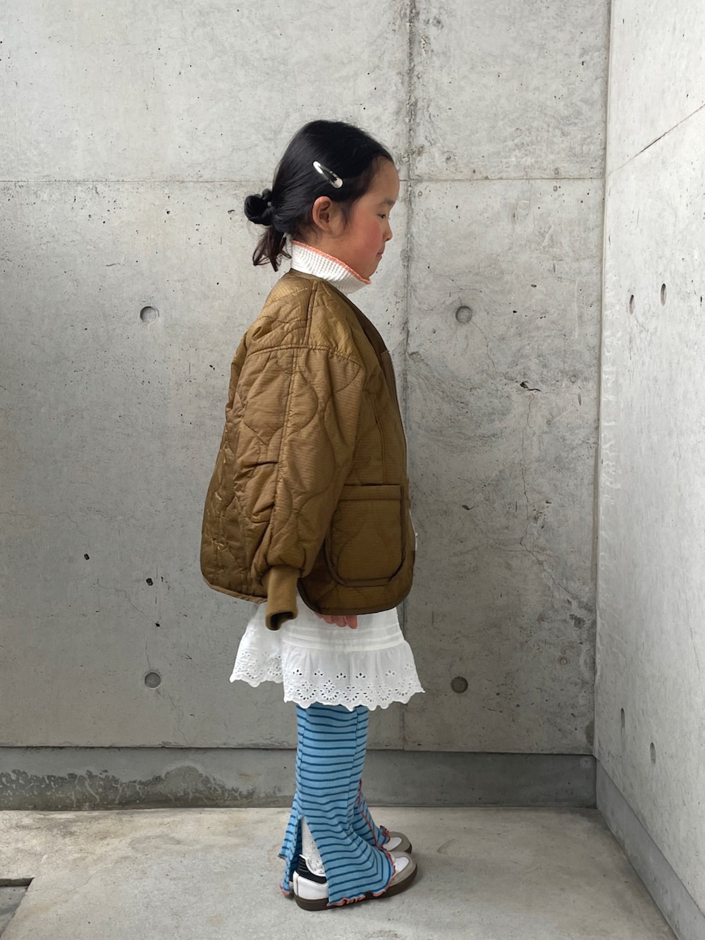 ブラウン系のダウンジャケット/コート、ホワイト系のパンツ、グレー系のスウェットを着用したキッズの春コーディネートの3枚目の写真