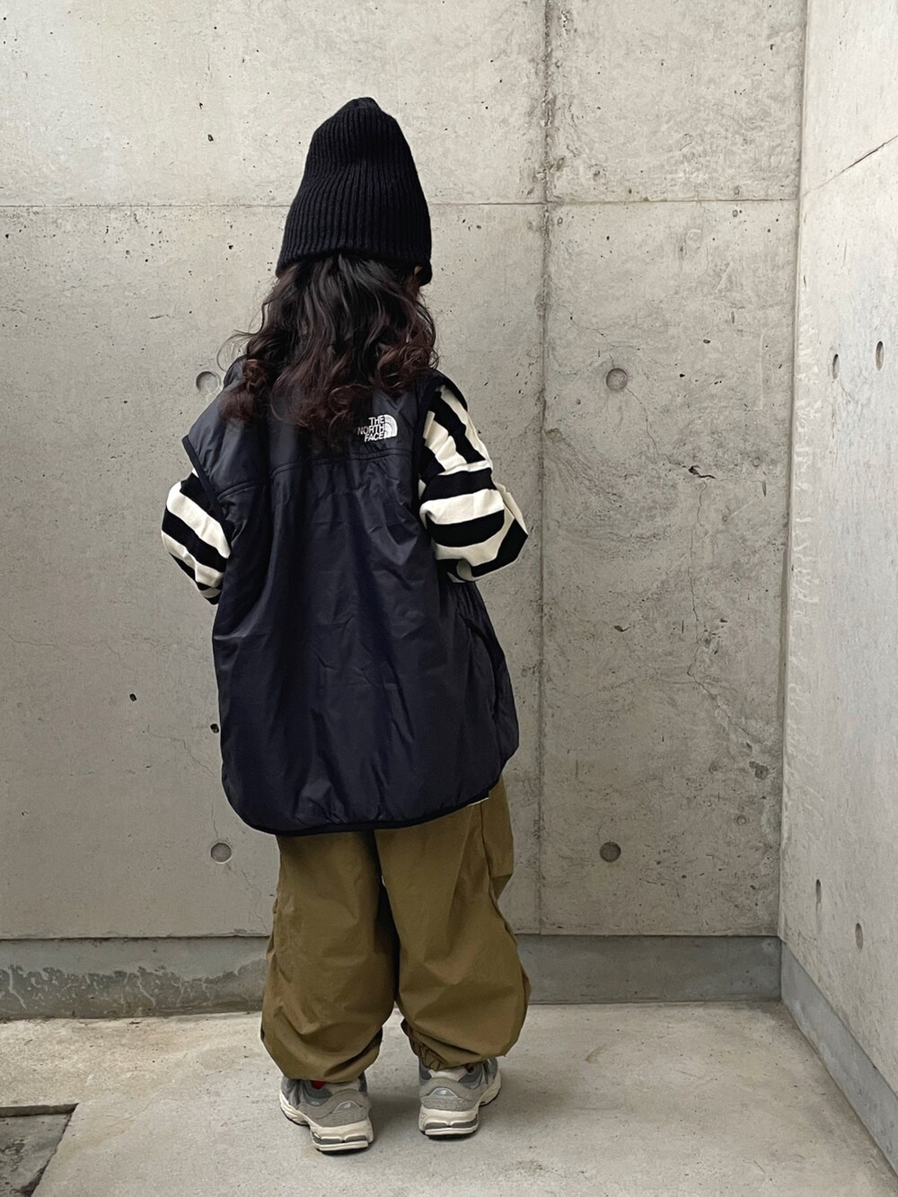 ブラック系のベスト、ブラック系のTシャツ/カットソー、グリーン系のパンツを着用したキッズの秋コーディネートの3枚目の写真