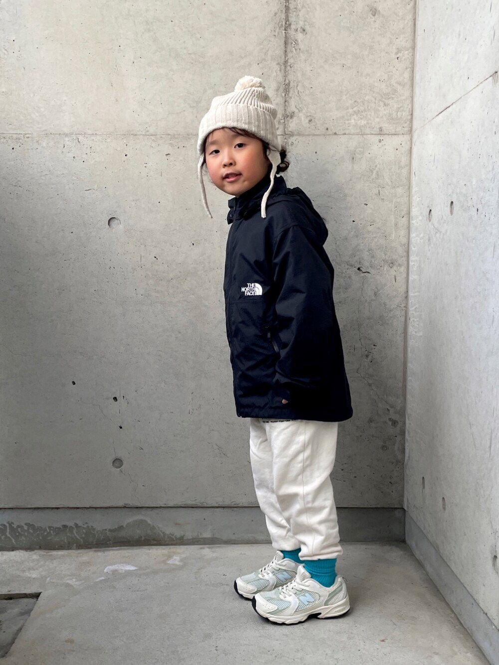 ブラック系のナイロンジャケット、ホワイト系のその他パンツ、ホワイト系のスウェットを着用したキッズの秋コーディネートの2枚目の写真