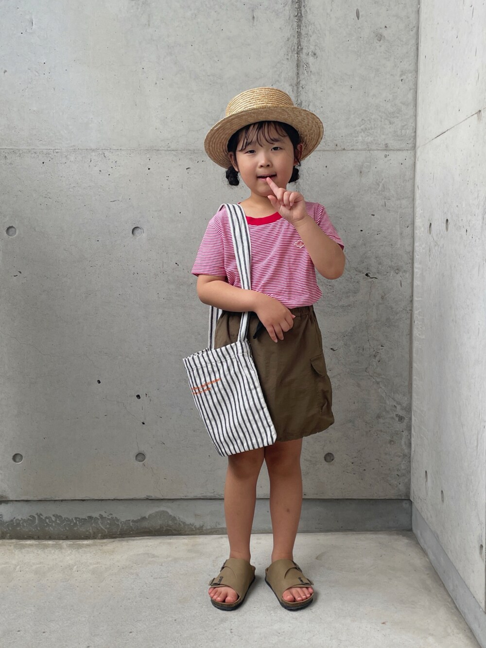 レッド系のTシャツ/カットソー、グリーン系のスカート、ホワイト系のバッグを着用したキッズの夏コーディネートの4枚目の写真